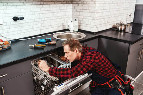 handy man fixing dishwasher